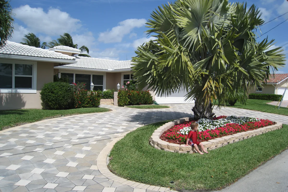 Single-storey house with a palm and paved driveway in Pompano Beach, Florida